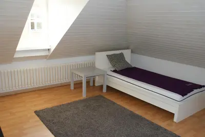 a bedroom with a white bed with a skylight at Kränzlin Hotel in St. Gallen