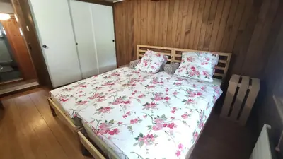 a bedroom with a bed with a floral bedspread and pillows at romatisches Chalet mit Bodenseesicht in Wolfhalden