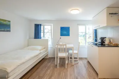 a small room with a bed and a table at CasaMia Flawil in Flawil