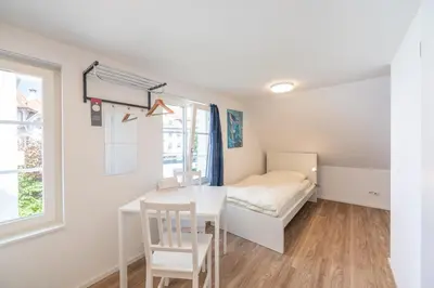 a bedroom with a desk and a bed and a window at CasaMia Flawil in Flawil
