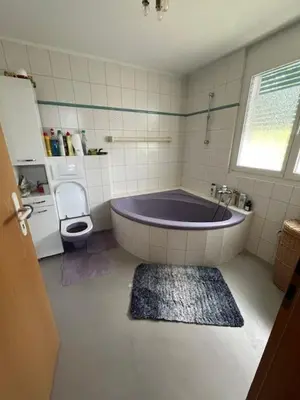 a bathroom with a tub and a toilet at Holiday home with pool & dream view over Lake Constance in Rorschacherberg