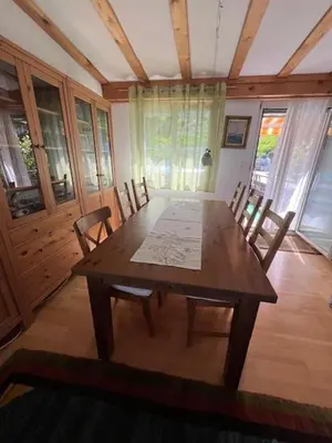 a wooden table and chairs in a room at Holiday home with pool & dream view over Lake Constance in Rorschacherberg
