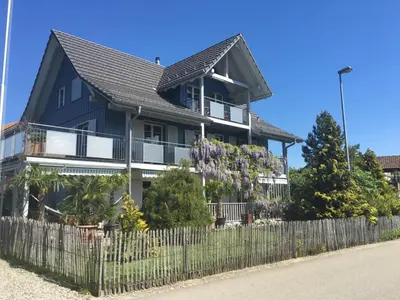 a large house with a fence in front of it at Apartment with charm and dream view in Hosenruck