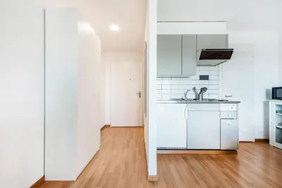 a kitchen with white appliances and a wooden floor at SOHO 4B !Gratis Parken, Free Parking! in Kreuzlingen