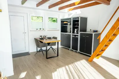 a kitchen with a wooden table and a dining room at Seesicht - Rückzugsort oberhalb vom Bodensee in Wienacht-Tobel