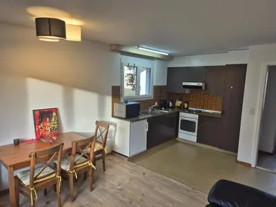 a kitchen and dining room with a table and chairs at SwissRest - Self Check-In in Sevelen