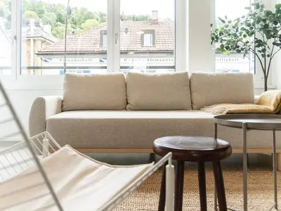 a living room with a couch in front of a window at Modernes Hostel, Privatzimmer in Shared Apartment, WYBA Living in St. Gallen