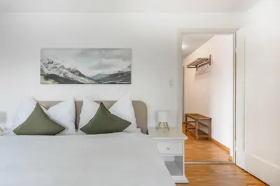 a white bedroom with a white bed with green pillows at SOHO3A !Gratis Parken, Free Parking! in Kreuzlingen