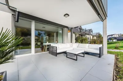 a patio with white couches and a table at DESIGN-APARTMENT 1 !Gratis parken, Free Parking! in Kreuzlingen