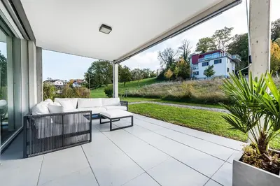 an outdoor patio with a couch and a table at DESIGN-APARTMENT 1 !Gratis parken, Free Parking! in Kreuzlingen