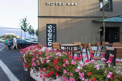 a table and chairs and flowers in a parking lot at Hotel one66 (free parking garage) in St. Gallen