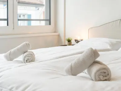 a bedroom with two white beds with towels on them at Stilvoll & zentral in St Gallen -WYBA Living Rio in St. Gallen