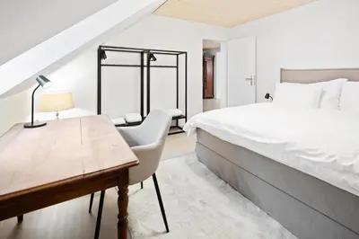 a bedroom with a bed and a desk with a lamp at BLIV Grosszügiges Altbaujuwel im Zentrum in St. Gallen