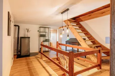 a wooden staircase in a room with a kitchen at Das aussergewöhnliche Gäste- und Ferienhaus in Güttingen