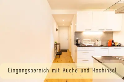 a kitchen with white cabinets and wooden floors at Jasminkas Host 3 - Stadtwohnung mit Küche & gratis Parkplatz in St. Gallen