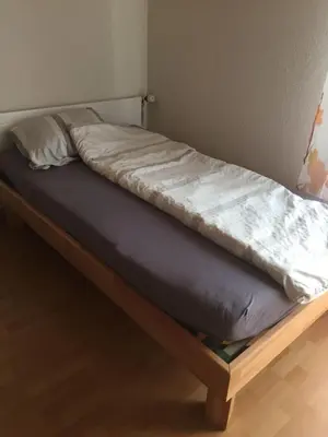 a bed with a mattress on a wooden bed frame at 3 Zi Gartenwohnung in Buchs