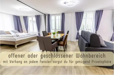 a living room with a table and a couch at Modern 80qm Flat with Balcony & free Parking in St. Gallen