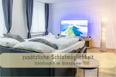 a room with two beds and a painting on the wall at Modern 80qm Flat with Balcony & free Parking in St. Gallen
