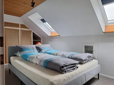 three pillows on a couch in a room with skylights at Dachwohnung in Niederuzwil