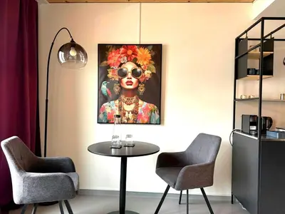 a room with two chairs and a table and a painting at RS Boardinghouse Self Check-In Free Parking in St. Gallen