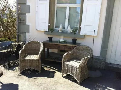 two wicker chairs and a table in front of a window at Apartment Kleines Loft by Interhome in Gais