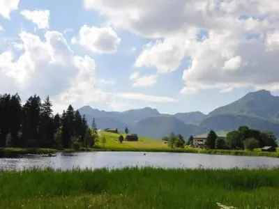 a lake in a field with mountains in the background at Apartment Chäserruggblick by Interhome in Unterwasser