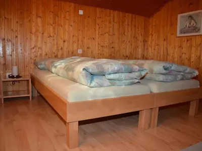 a bed in a wooden room with pillows on it at Apartment Sutter in Brülisau bei Appenzell by Interhome in Brülisau