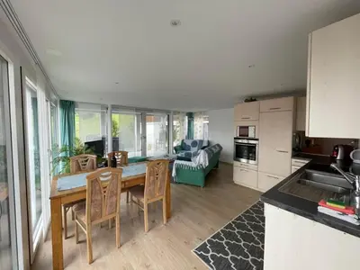 a kitchen and living room with a table and chairs at Apartment Hälmli by Interhome in Heiden