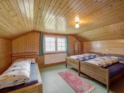 a bedroom with two beds in a log cabin at Apartment Hautle by Interhome in Appenzell Innerrhoden