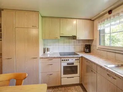a kitchen with wooden cabinets and a stove top oven at Apartment Hautle by Interhome in Appenzell Innerrhoden