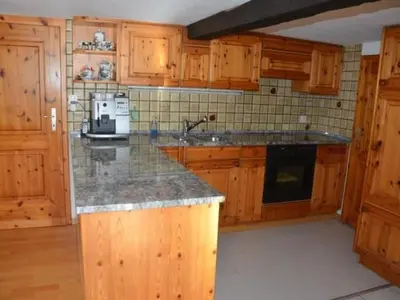 a kitchen with wooden cabinets and a granite counter top at Apartment Breiten by Interhome in Brunnadern