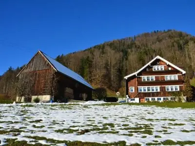 a barn and a house in a field with snow at Apartment Breiten by Interhome in Brunnadern