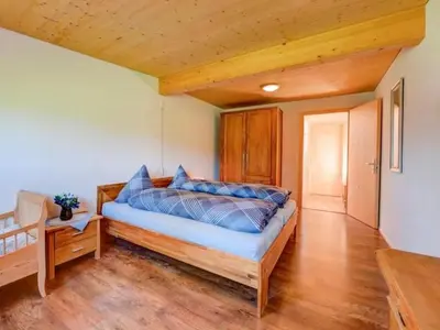 a bedroom with a bed and a wooden floor at Apartment Bauernhof Fendrig - neue Wohnung by Interhome in Haslen