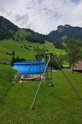 a swing set in a grassy field with a hill at Apartment Ferien im Gugger - Wohnung Stockberg by Interhome in Nesslau