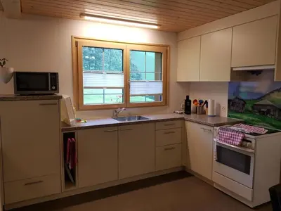 a kitchen with white cabinets and a sink and a microwave at Apartment Ferien im Gugger - Wohnung Stockberg by Interhome in Nesslau