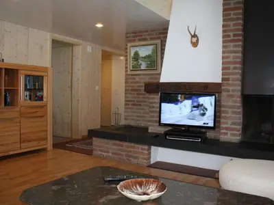 a living room with a tv on a brick wall at Apartment Casa Uccello by Interhome in Wildhaus