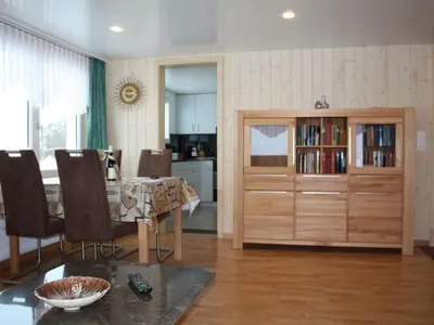a living room with a table and a large wooden cabinet at Apartment Casa Uccello by Interhome in Wildhaus