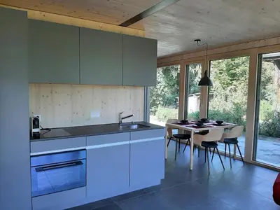 a kitchen with a sink and a table with chairs at Holiday Home Gartenbungalow 2 - 3 Personen by Interhome in Arbon