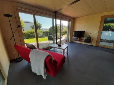a living room with a red couch and a television at Holiday Home Gartenbungalow 2 - 3 Personen by Interhome in Arbon