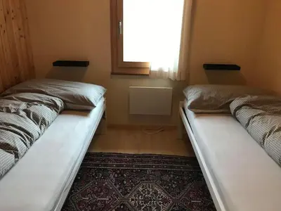 two beds in a room with a window and a rug at Holiday Home Soldanella by Interhome in Appenzell