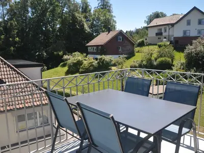 a table and chairs on the balcony of a house at Apartment Rätia by Interhome in Wolfhalden