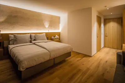 a bedroom with a large bed and a wooden floor at Säntis - das Hotel in Schwagalp