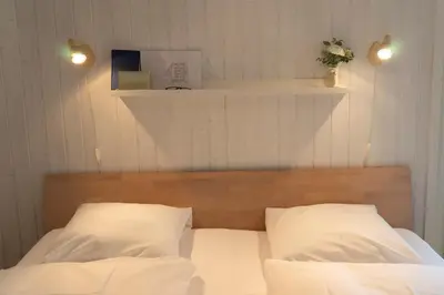 a bedroom with a bed with white sheets and two pillows at Studio Muerner in Wildhaus