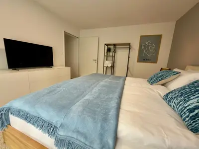 a bed with blue and white pillows on it at Sunset I Bodensee I St Gallen I Bregenz I Appenzell I Vaduz in Rorschacherberg