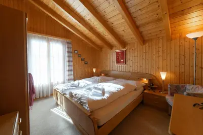 a bedroom with a large bed in a wooden room at Sonnegge in Wildhaus