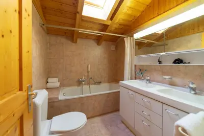 a bathroom with a toilet and a tub and a sink at Sonnegge in Wildhaus