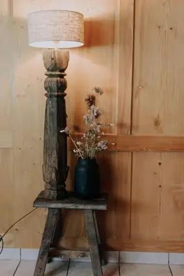 a lamp on a table with a vase on it at Quiet exclusive house for 6 people in Brülisau