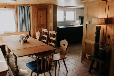 a dining room with a wooden table and chairs at Quiet exclusive house for 6 people in Brülisau