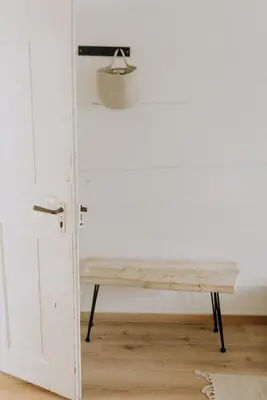 a wooden bench in front of a door at Zimmer Appenzell im Appenzeller Ferienhaus in Brülisau