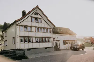 a house with a car parked in front of it at Zimmer Appenzell im Appenzeller Ferienhaus in Brülisau